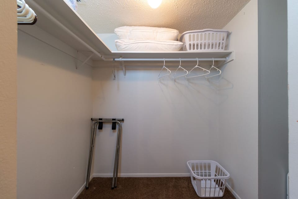 Primary Suite Walk-In Closet: Ample storage space in the walk-in closet connected to the primary bathroom. Plenty of room for your belongings during your stay.
