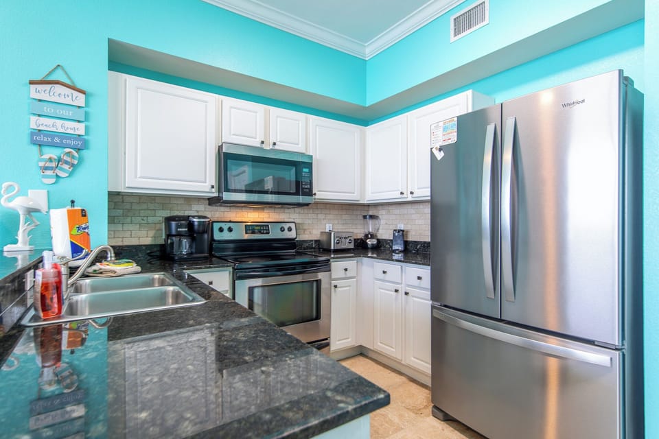 Fully stocked kitchen with stainless steel appliances.