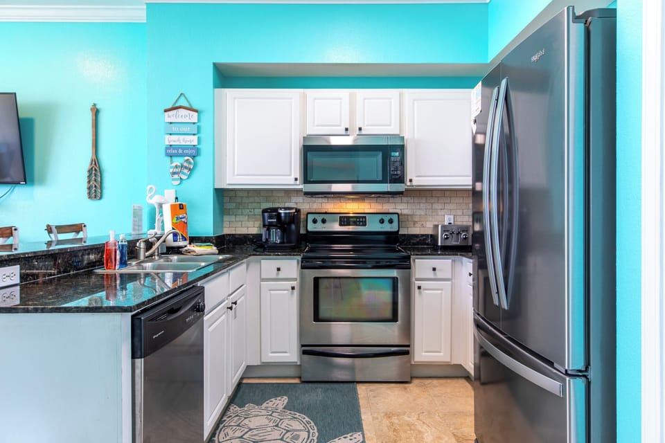 Fully stocked kitchen with stainless steel appliances.
