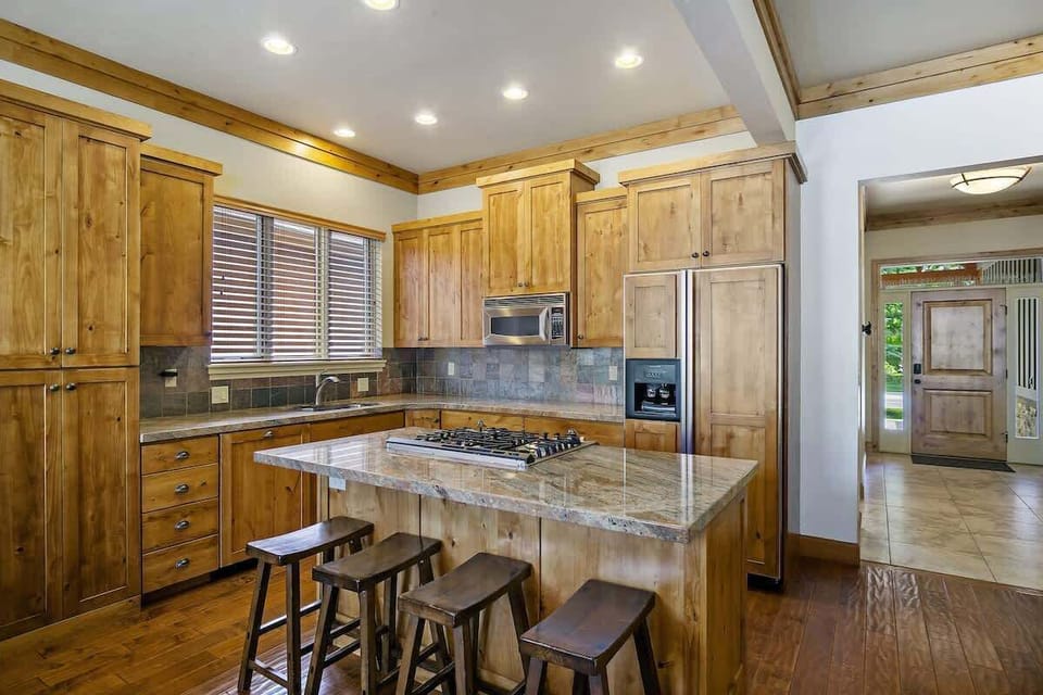 Kitchen with 4 barstools and the entry from the front door.