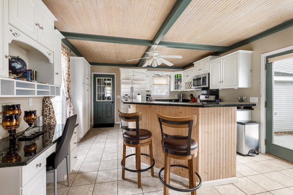 Bright kitchen island w/ bar stools, perfect for casual bites or morning coffee.