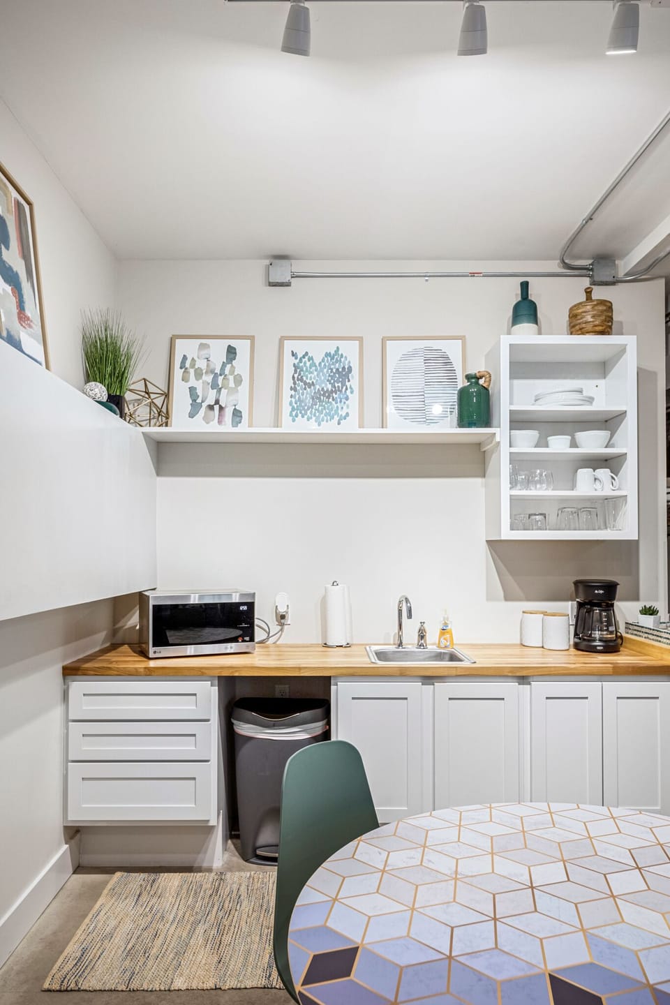 Handy kitchenette w/ mini fridge, microwave & open shelving for easy snacks & coffee breaks.