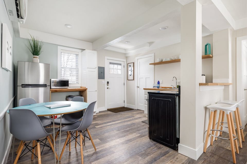 Open dining area w/ sleek table, modern chairs & breakfast bar by the kitchen