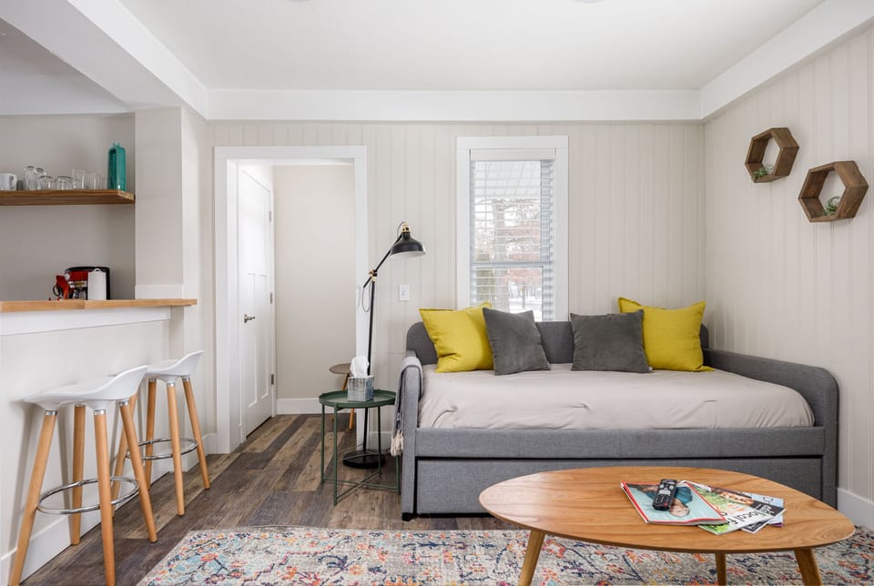 Cozy lounge area w/ sofa, accent pillows & open flow to dining nook