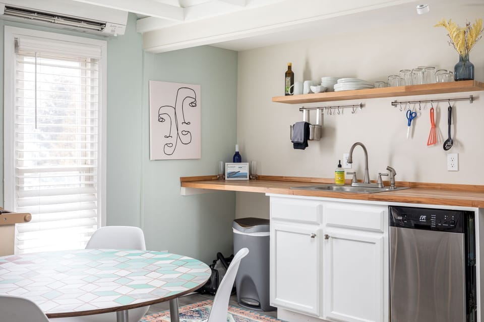 Whip up meals in the tidy kitchen w/ wood countertops, open shelves & modern appliances.