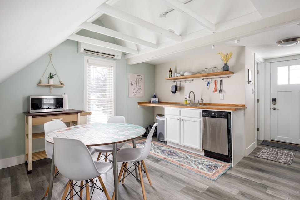 Cook in the airy kitchen w/ open shelving & dine at the sunny table beneath charming sloped ceilings.