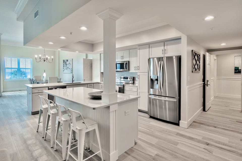 Kitchen of 201A with new appliances and 8 surrounding bar stools