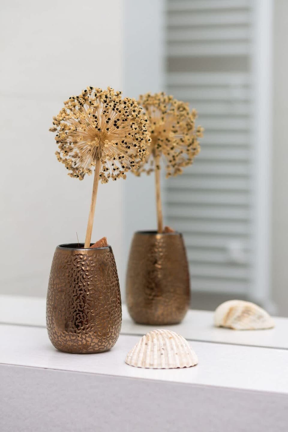A decorative vase next to which lies a shell.