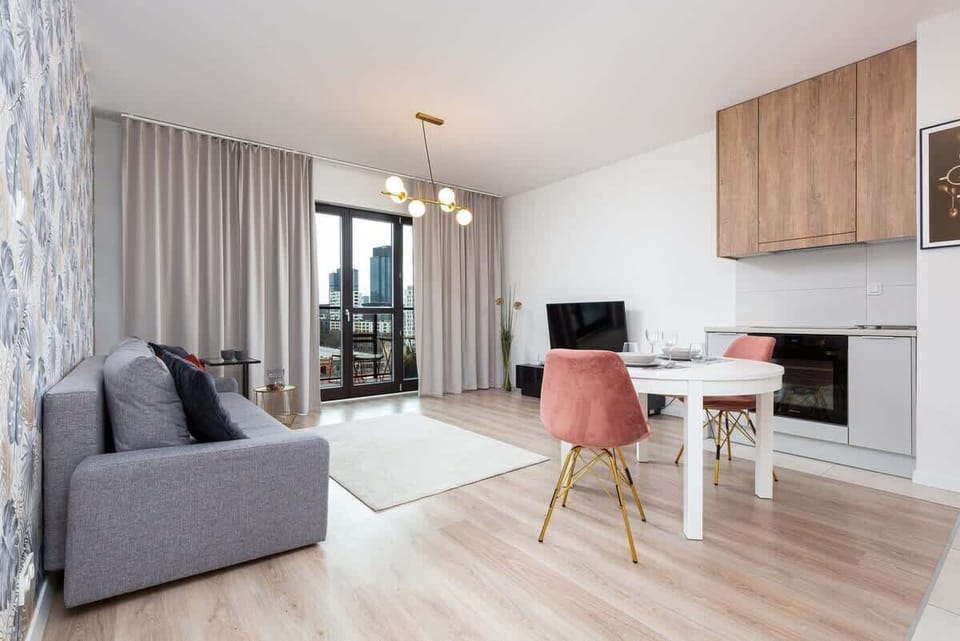 A wider perspective of the living room showing how the table coherently connects the kitchenette to the living area.