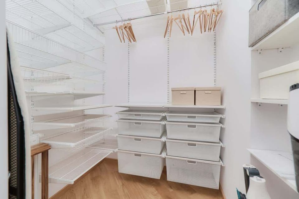  A dressing-room area with open shelves, hangers, and a minimalist design.