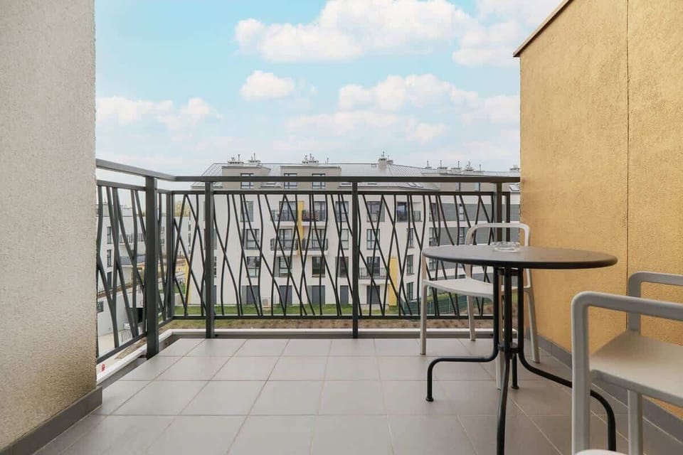 A balcony view showing a well-maintained residential area and open sky.