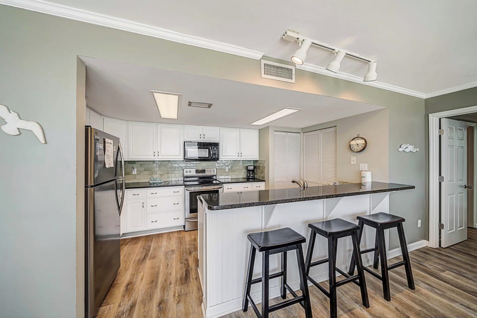 There is a dining table, perfect for enjoying a meal or playing a game, as well as additional breakfast bar seating.