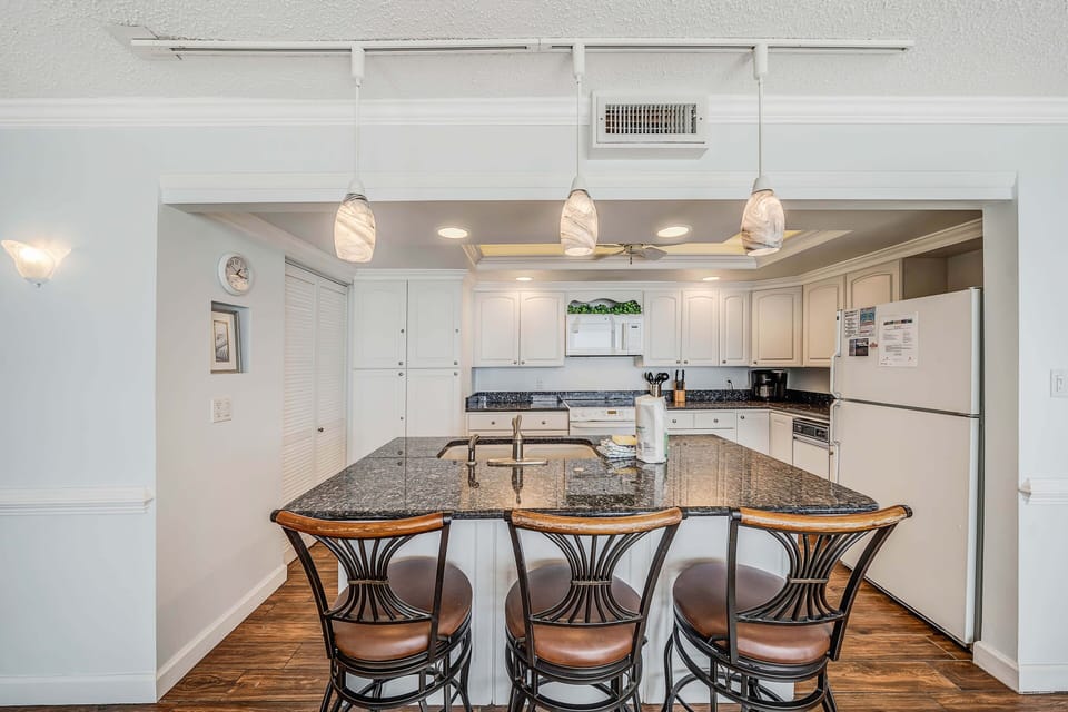 There is a dining table that seats 6, perfect to enjoy a meal or play a game, as well as additional breakfast bar seating.