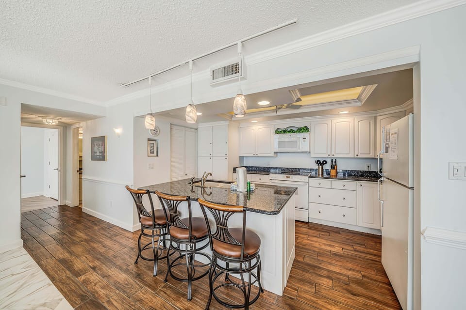 There is a dining table that seats 6, perfect to enjoy a meal or play a game, as well as additional breakfast bar seating.