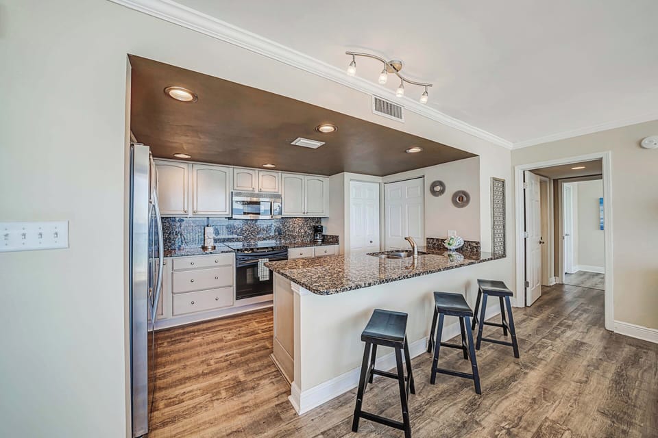 There is a dining table, perfect for enjoying a meal or playing a game, as well as additional breakfast bar seating.