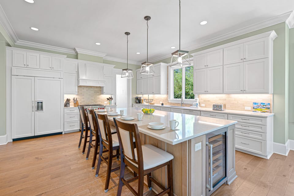 Oversized island with seating for six, the space features custom cabinetry, premium appliances, and expansive quartz countertops.