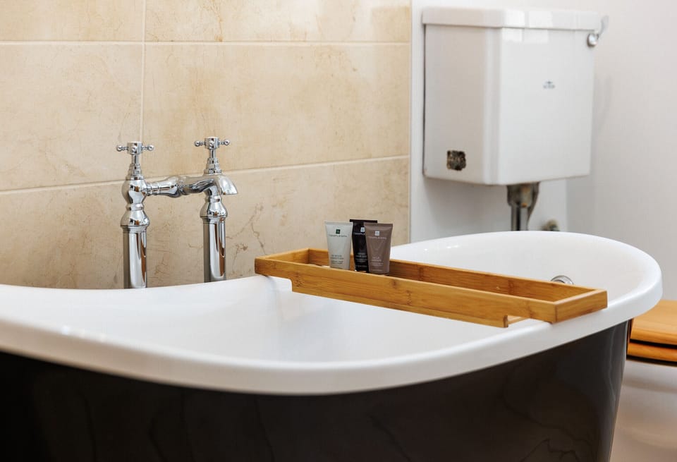The downstairs bathroom at 1 Apse Castle Cottages features a beautiful freestanding roll-top bath and underfloor heating, creating a warm and relaxing space to unwind after exploring the Isle of Wight. A lovely comfort for summer holidays on the Isle of Wight.