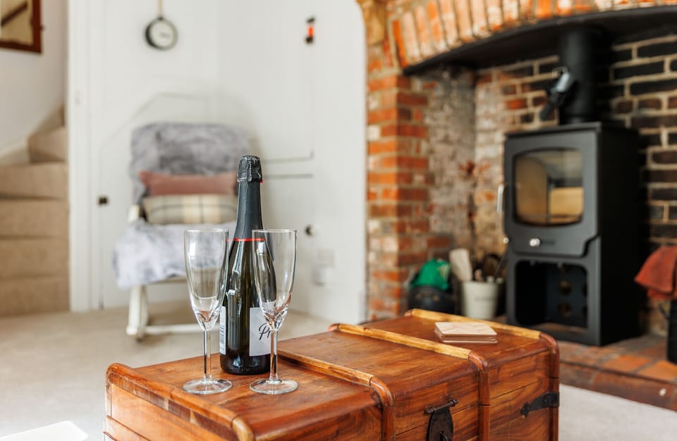 The charming inglenook fireplace and log-burning stove create a warm and cosy focal point in the living room at 1 Apse Castle Cottages. A welcoming place to relax after exploring Shanklin and the Isle of Wight.