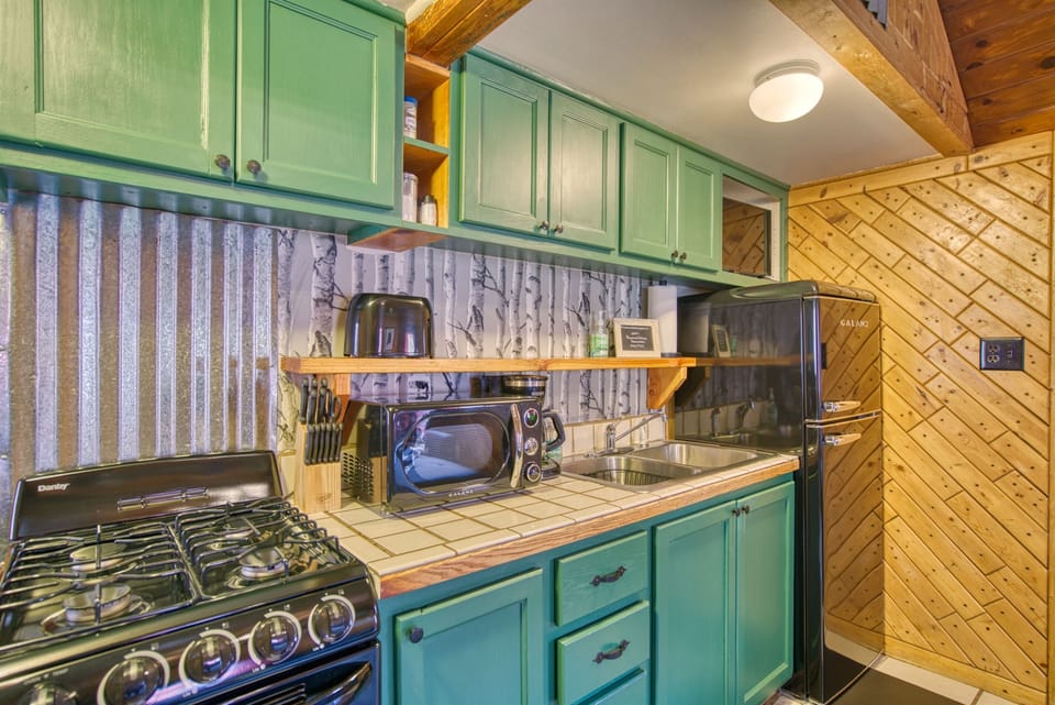 Retro style kitchen fully stocked with all cookware, dishes, and basic cooking spices.