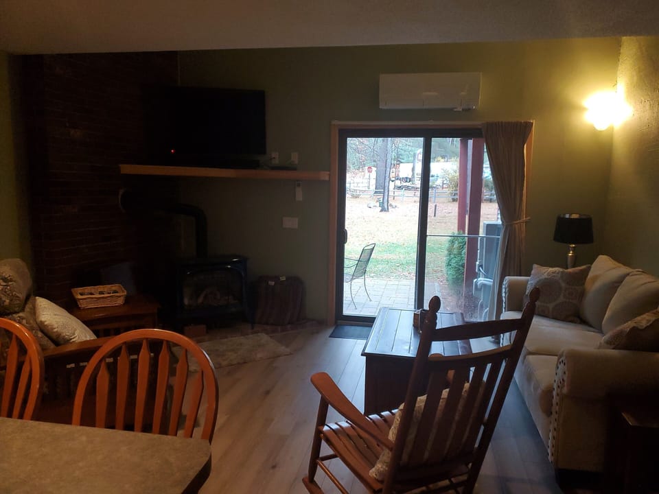 Open concept living room with mini-split, ceiling fan, smart TV & propane stove