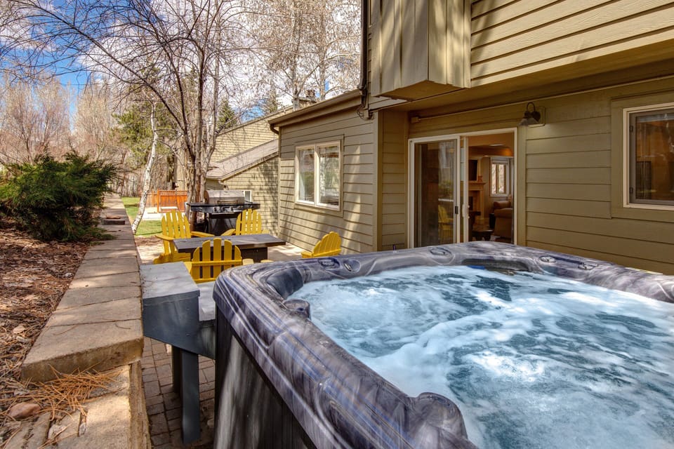 Private back patio with hot tub, seating for four, fire pit, and BBQ grill