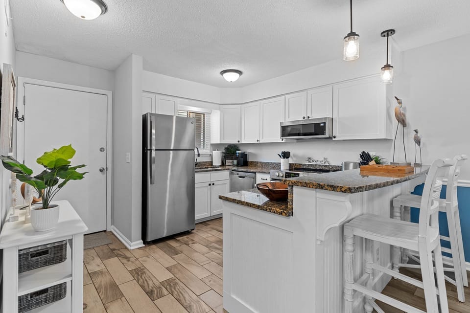 Your bright, fully-equipped kitchen awaits with granite countertops, stainless appliances, and a breakfast bar perfect for morning coffee.