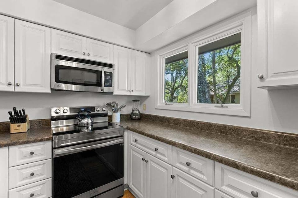 The beauty of the outdoors stream through the kitchen windows