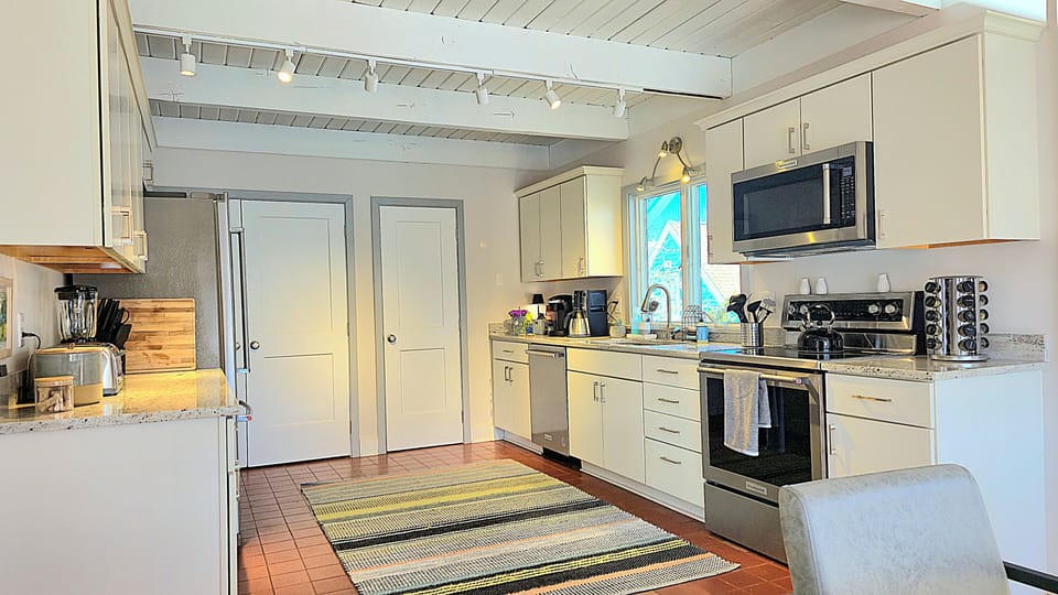 Complete gourmet kitchen with stainless appliances, quartz tops, soft close door