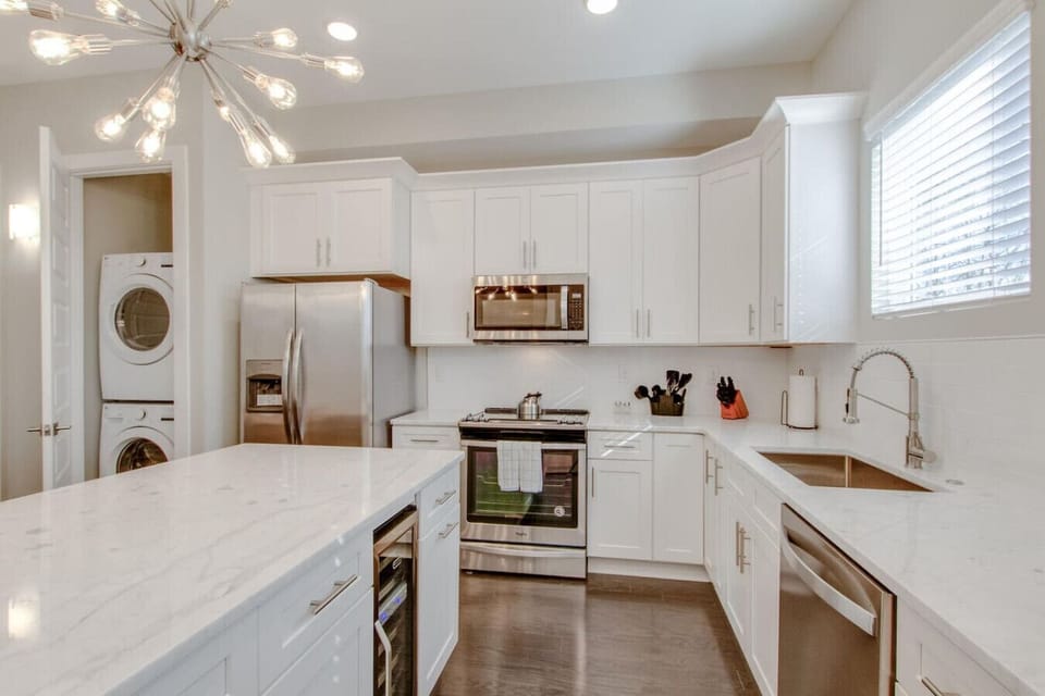 Fully equipped kitchen with stainless steel appliances, an island, and in-unit laundry