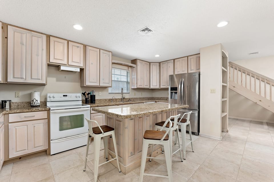 Granite countertop, breakfast bar sits four. 