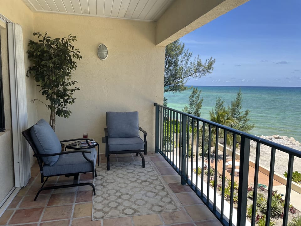 Master Bedroom Deck with cushioned rocking chairs to relax on and have a drink.