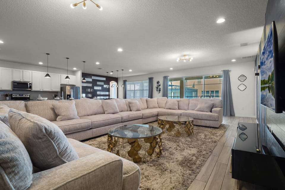 - Spacious living room with oversized sectional seating  
- Smart TV entertainment setup for relaxing family nights  
- Orlando vacation rental with bright open concept design