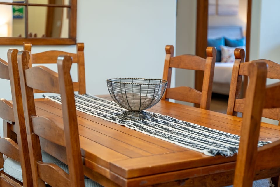 Wooden dining table with a wire bowl and table runner