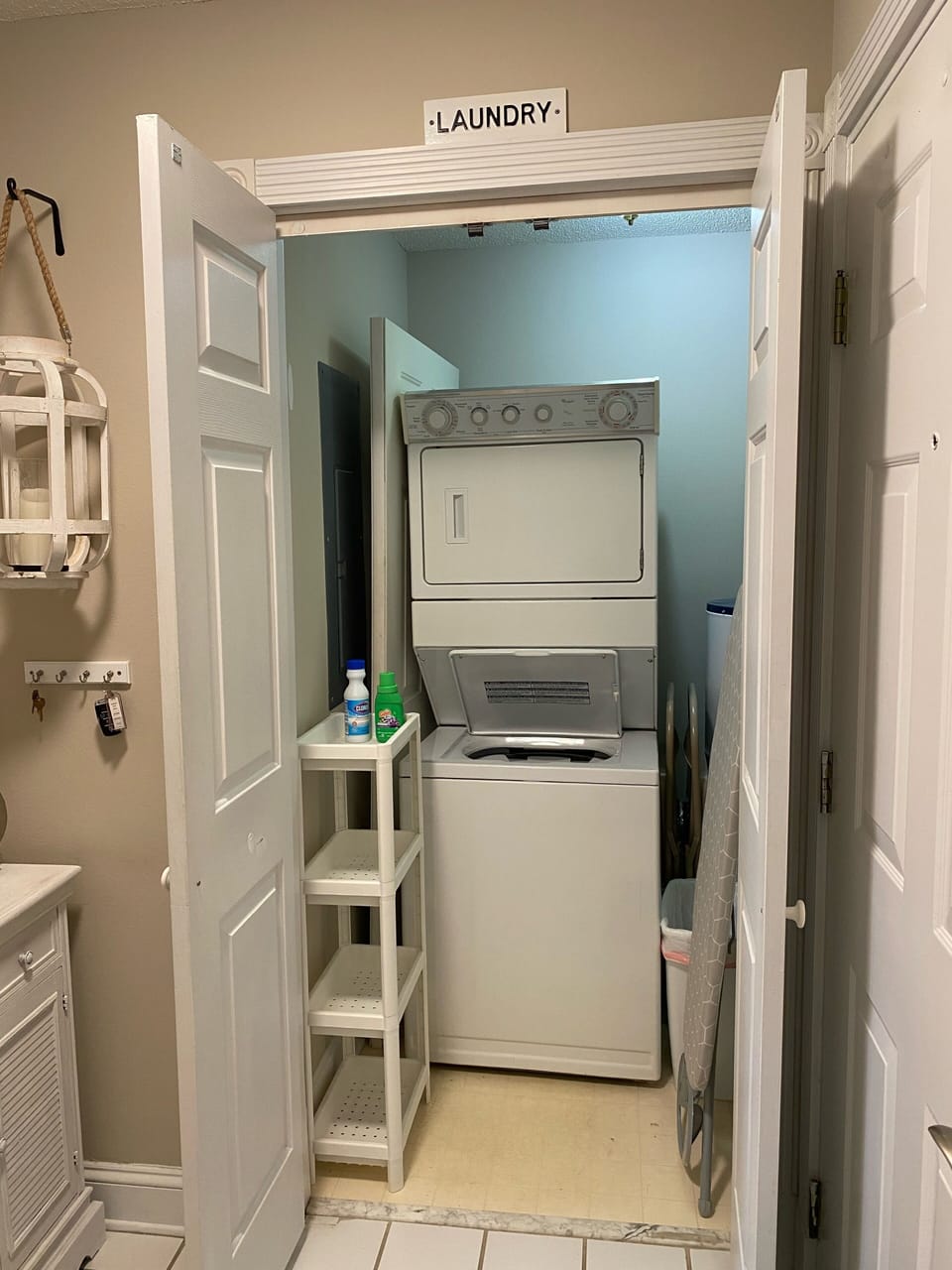 Laundry room includes washer, dryer, iron and ironing board.