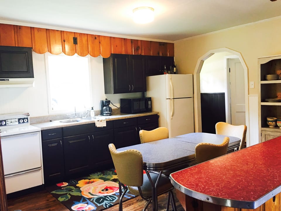 Eat in kitchen with mid-century table & chairs and red formica island