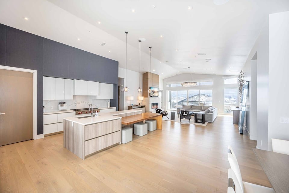 Open-concept kitchen and living area designed for group stays, featuring high-end appliances and mountain views.