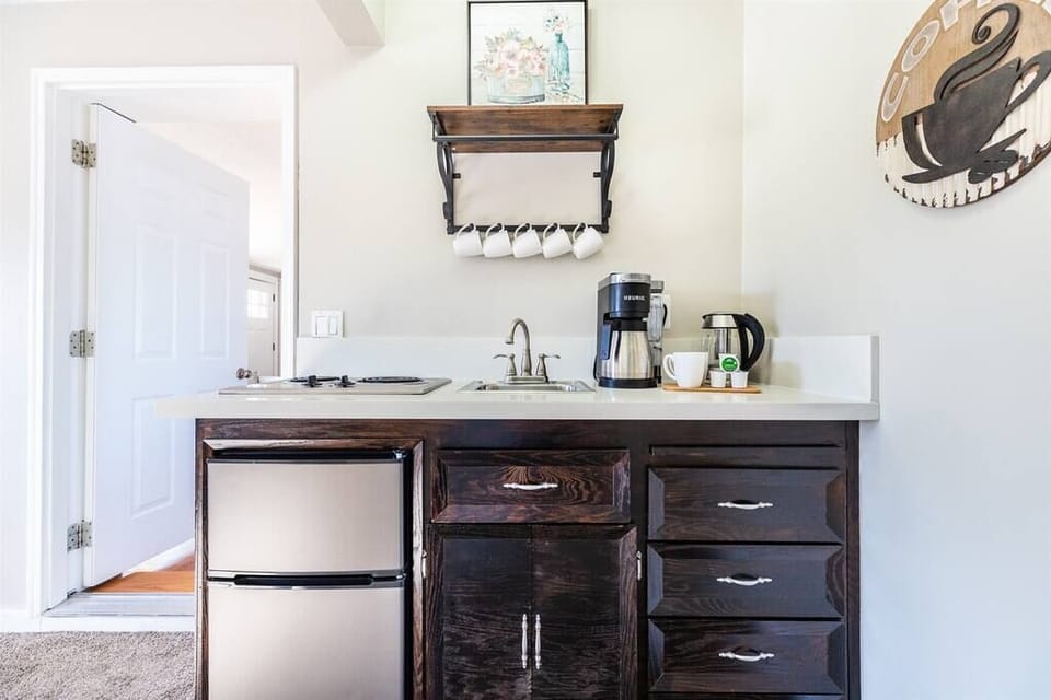 Mini fridge, stove, and sink with some storage space and small appliances to help you with what you may need during your time here. 