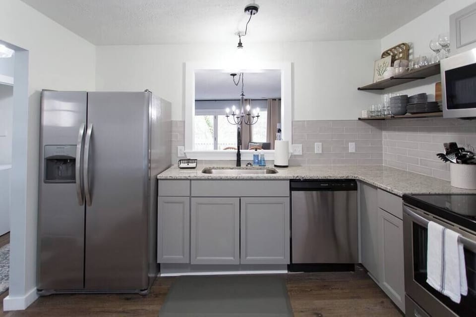A clean and modern kitchen with granite countertops and stainless steel appliances...including a dishwasher!