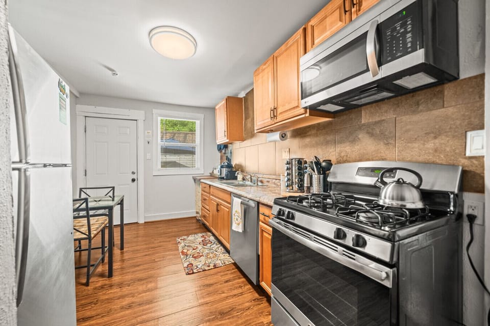 Full kitchen with eat-in area and backdoor leading to laundry and patio.