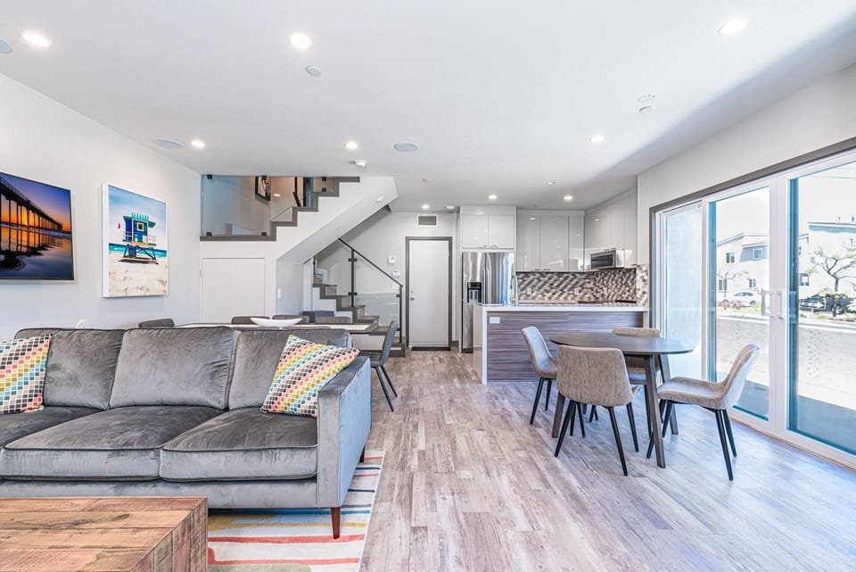View of the ground floor from the front door, with an open floor plan between kitchen and living areas. Back door (pictured) leads to garage.
                