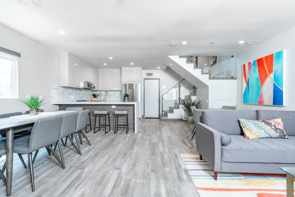 View of the ground floor from the front door, with an open floor plan between kitchen and living areas. Back door (pictured) leads to garage.
                