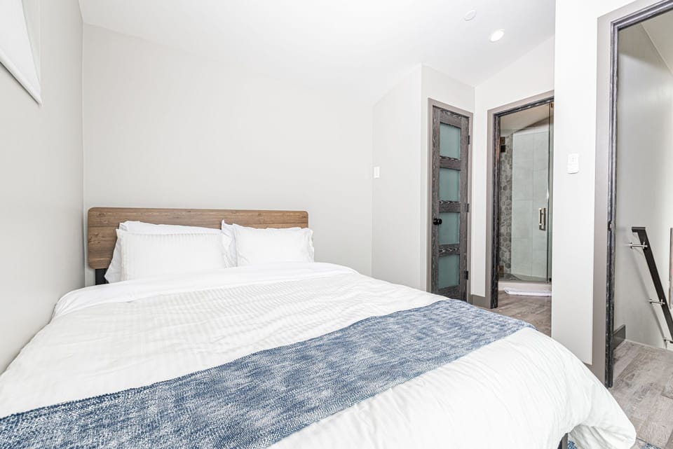 The third guest bedroom on the third floor includes a queen size bed, TV, and en suite bathroom.
                