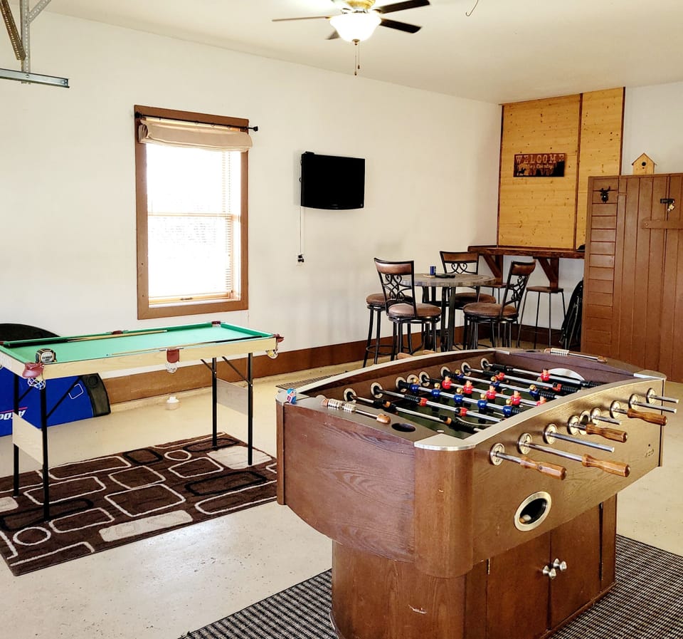 Foosball and mini pool table in game room/garage