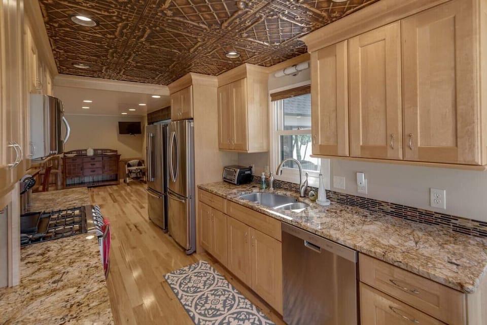 Kitchen area with wooden cabinets, sink and double door ref