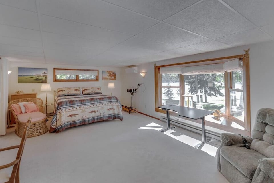 Spacious guest room with a desk area and natural lighting.
