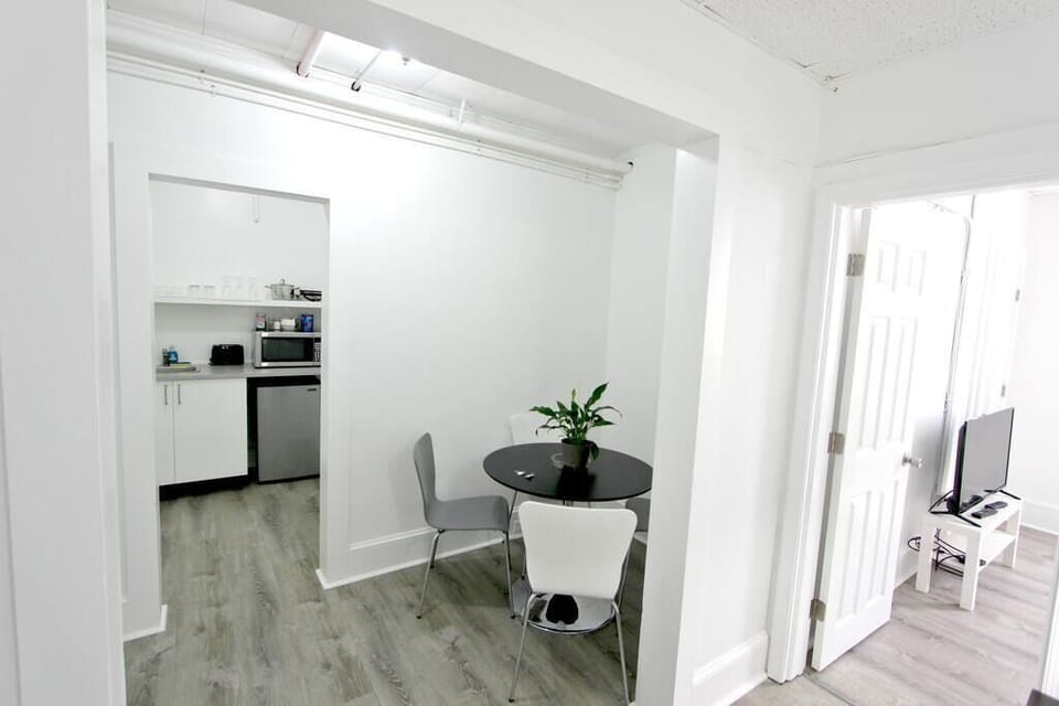 Dining space, open to Bedroom 1. Door shown is entrance to Bedroom 2.