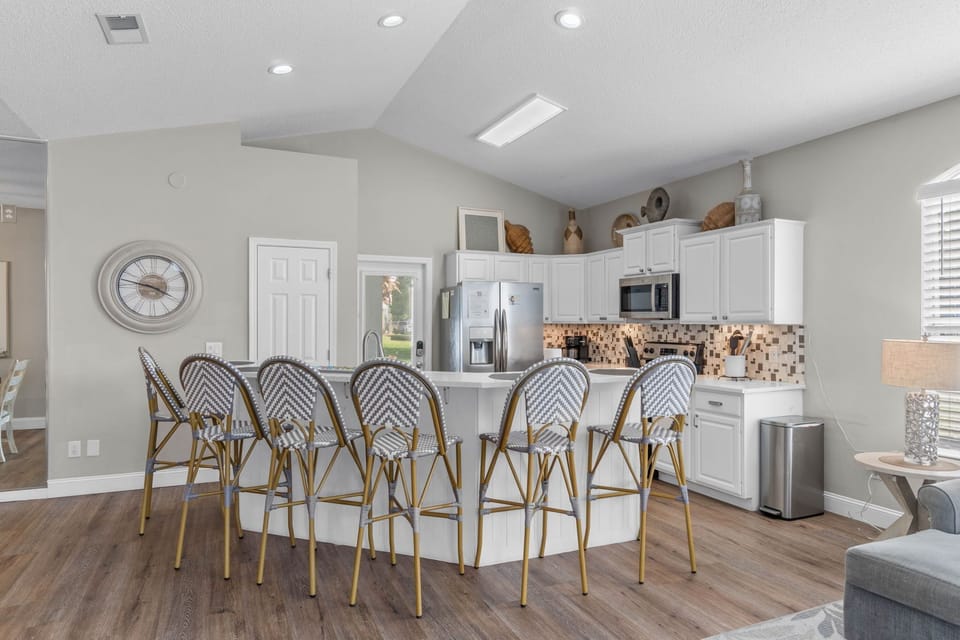 Bright open kitchen with vaulted ceilings and island seating for six
