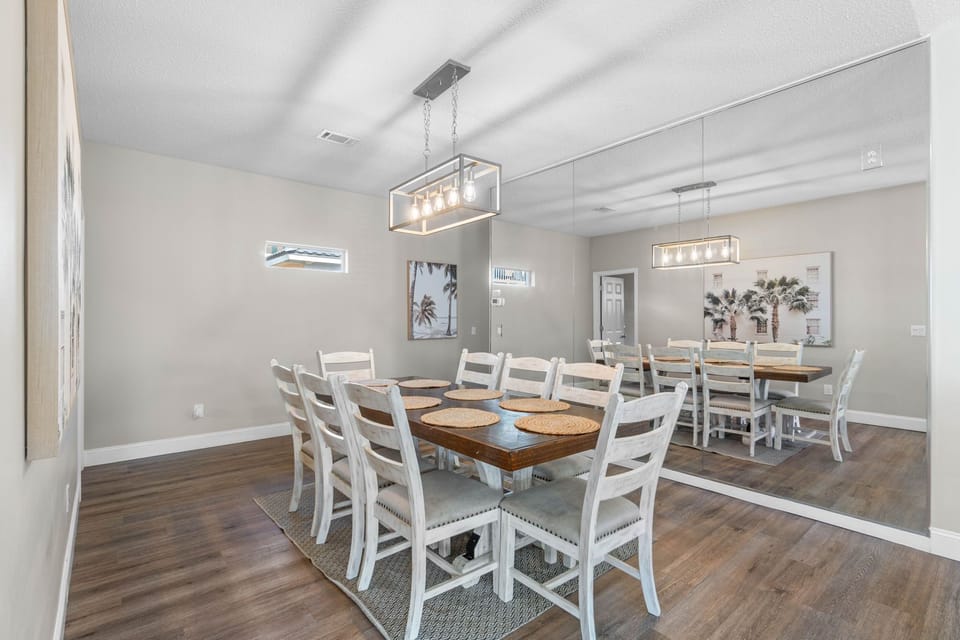 Spacious dining room with seating for 8 and a bright, modern coastal feel