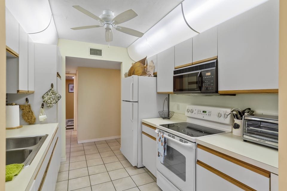 Efficient galley kitchen. Kitchen has new stainless steel fridge / microwave