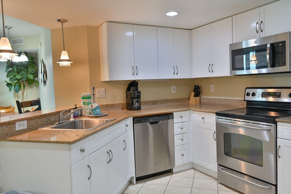 Modern kitchen with white cabinets, granite counters, and stainless appliances